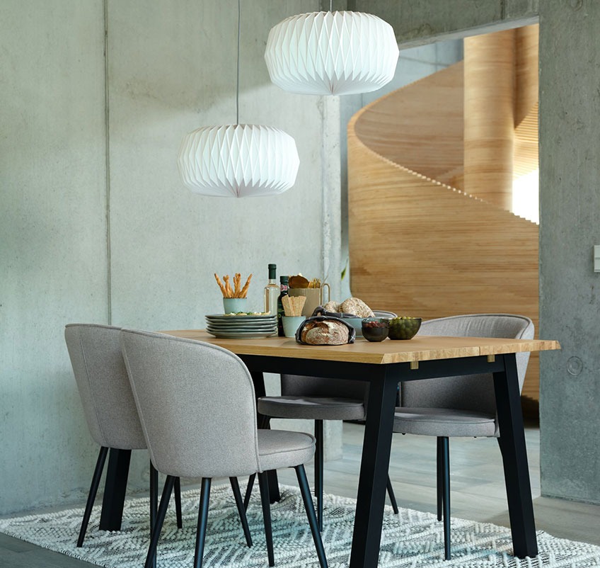 Spisebord med fire spisebordsstole i grå med sorte ben og to hvide loftslamper